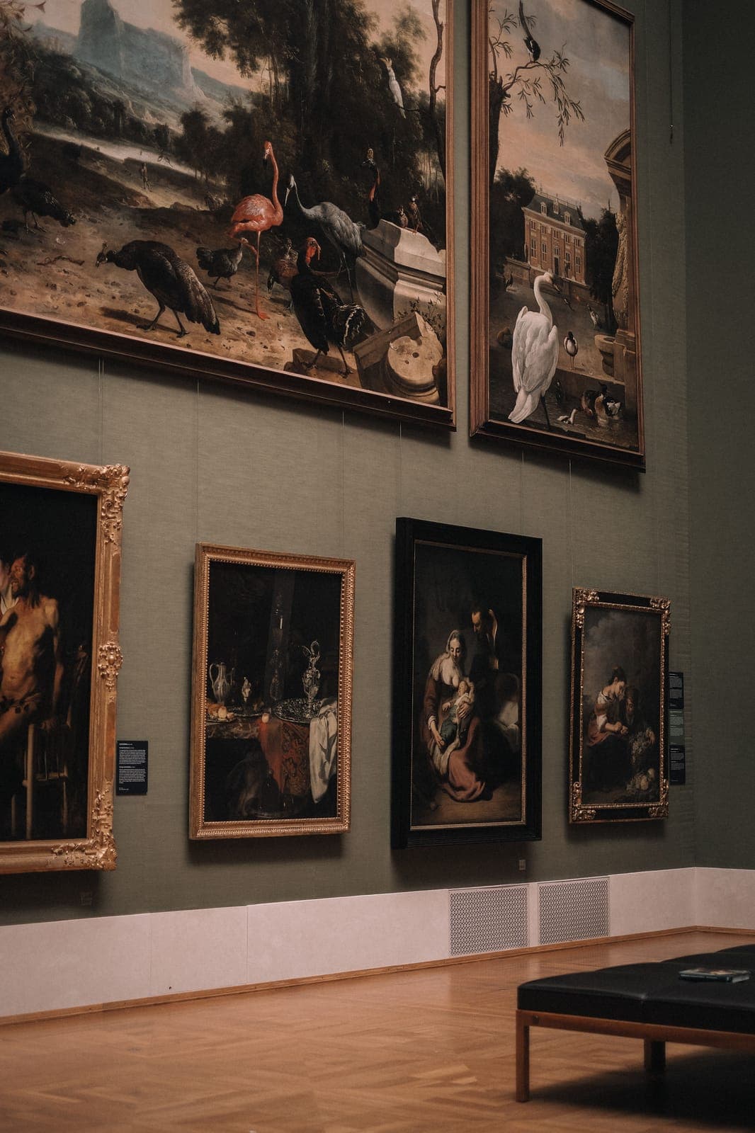 Classical oil paintings in gilded frames on a gallery wall